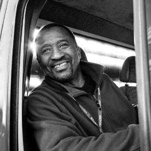 A Man In The Window Truck Smiling - San Francisco Compensation Lawyer -Boxer & Gerson, LLP