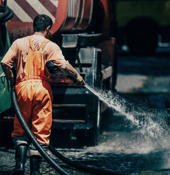 A Worker Holding A Hose Cleaning the Sidewalk with Water -Disability Lawyer -Boxer & Gerson, LLP